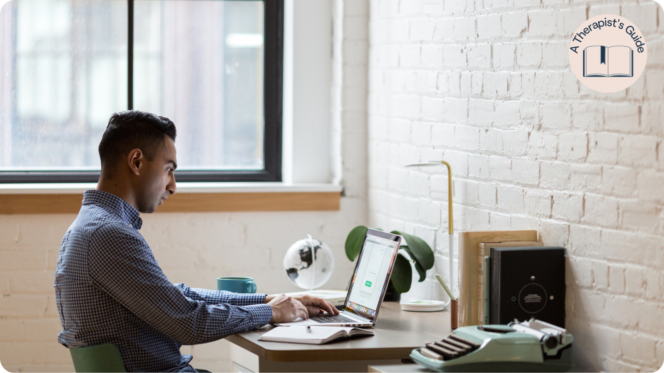 Indian male working at desk on laptop
